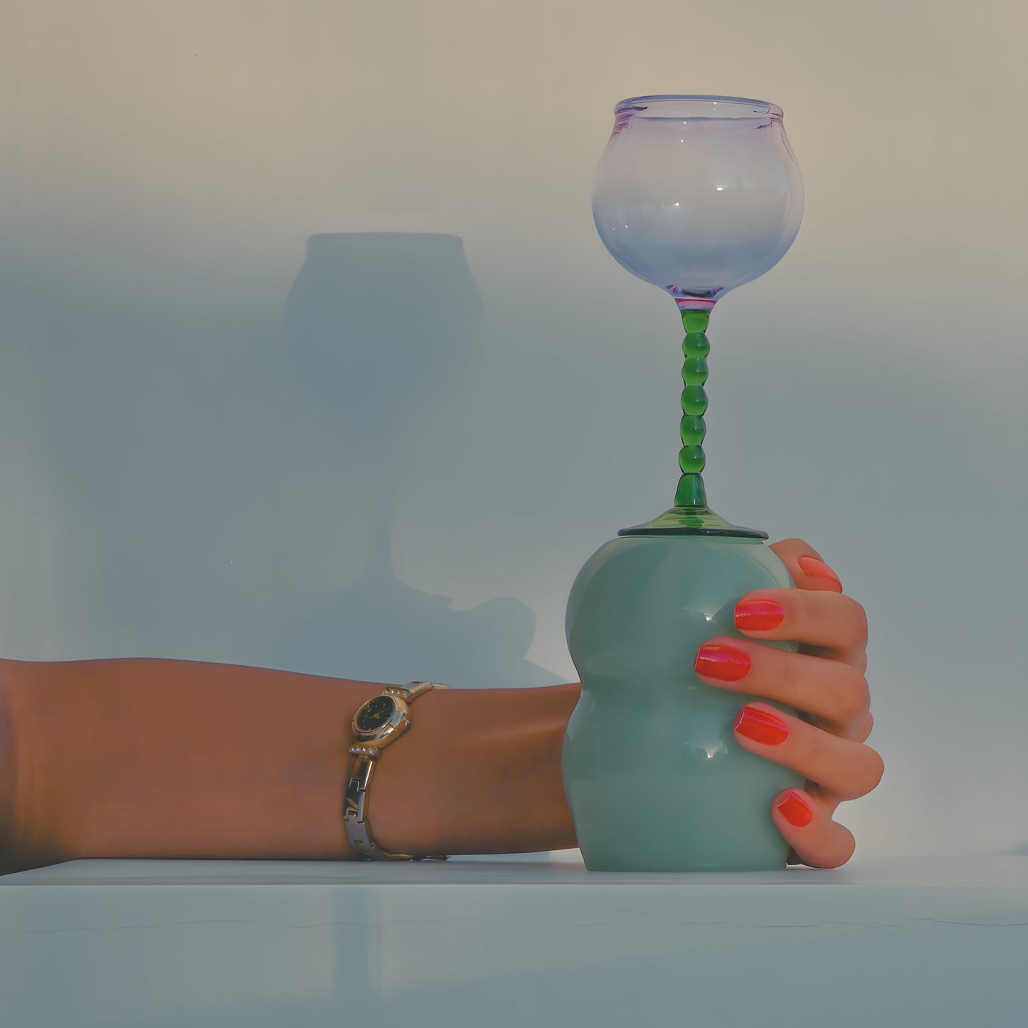 A handcrafted cup from the Dreamlike Collection, featuring whimsical curves and a vibrant interplay of color and light.