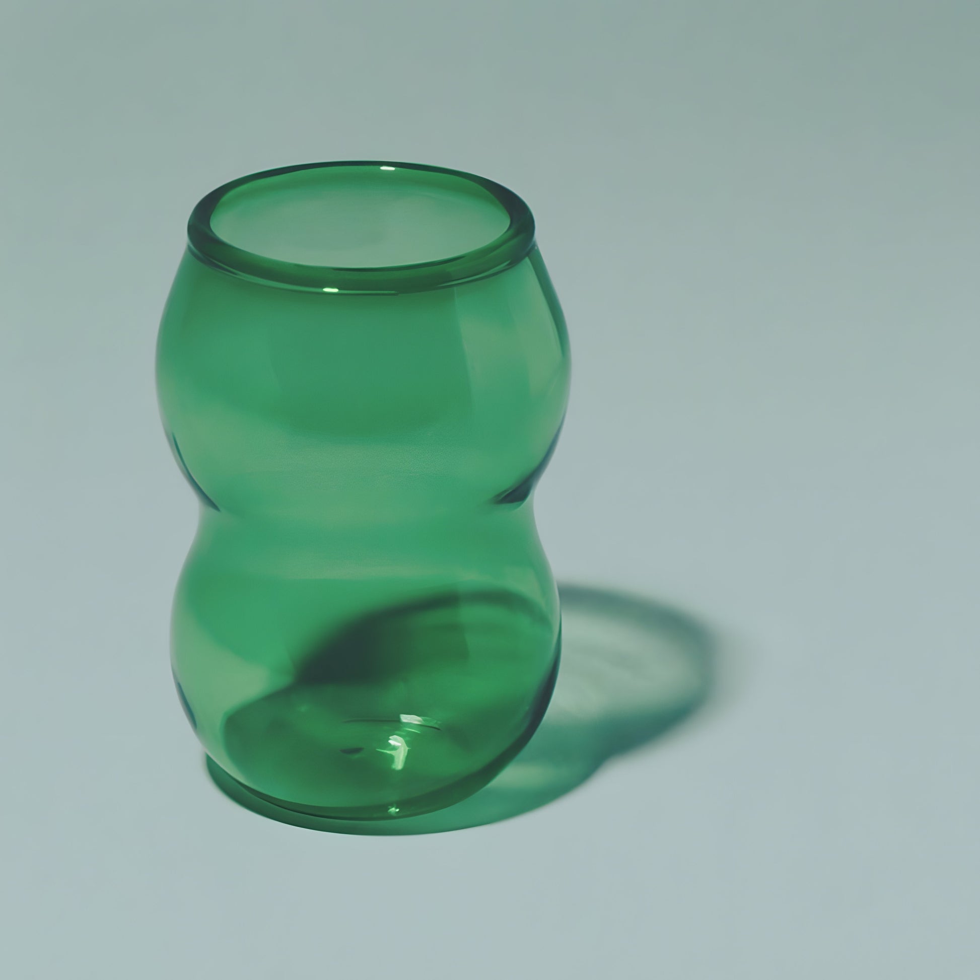 A handcrafted cup from the Dreamlike Collection, featuring whimsical curves and a vibrant interplay of color and light.