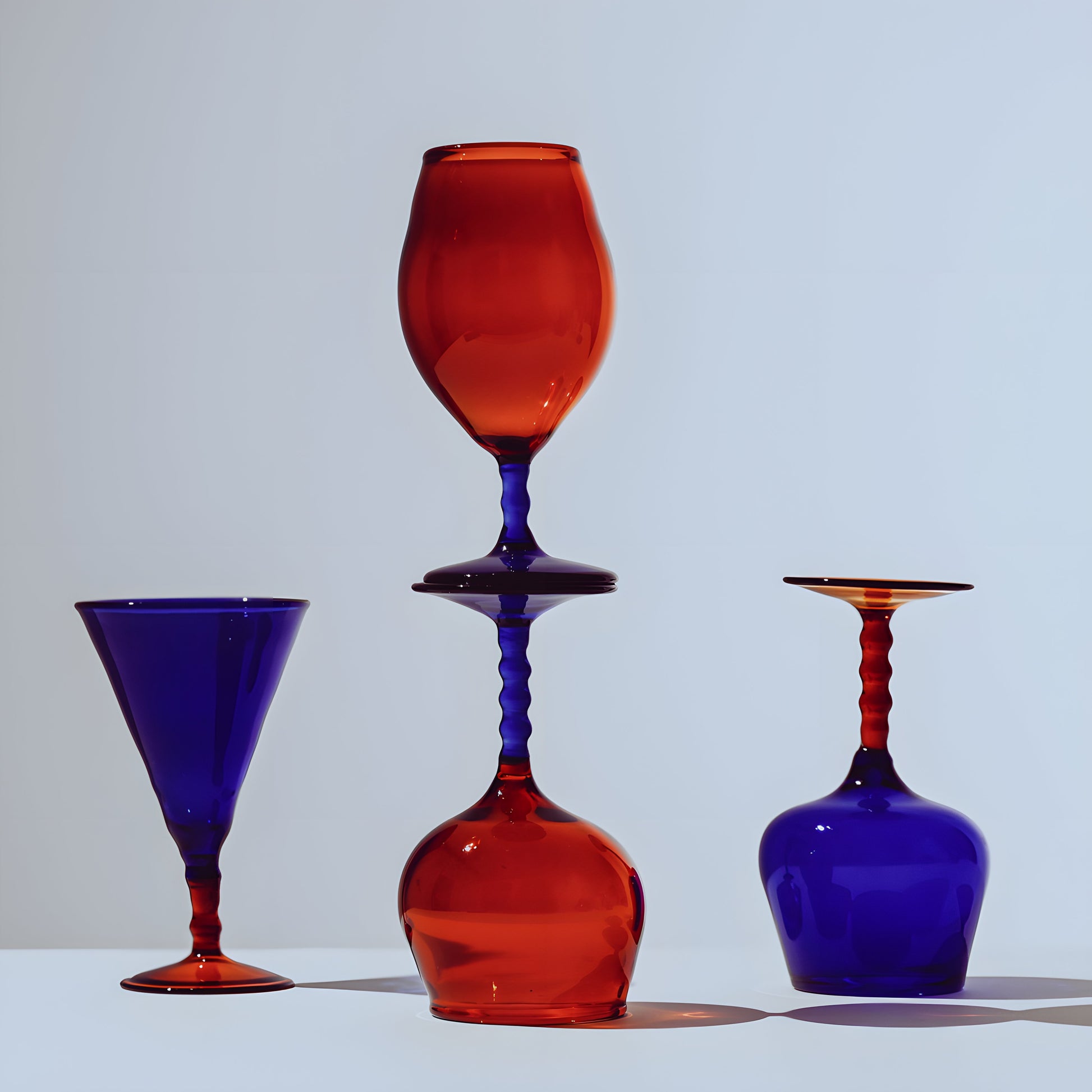 Vibrant Teta Edit Liquor glasses set in deep red and blue, featuring a unique stacked arrangement highlighting its handcrafted design.