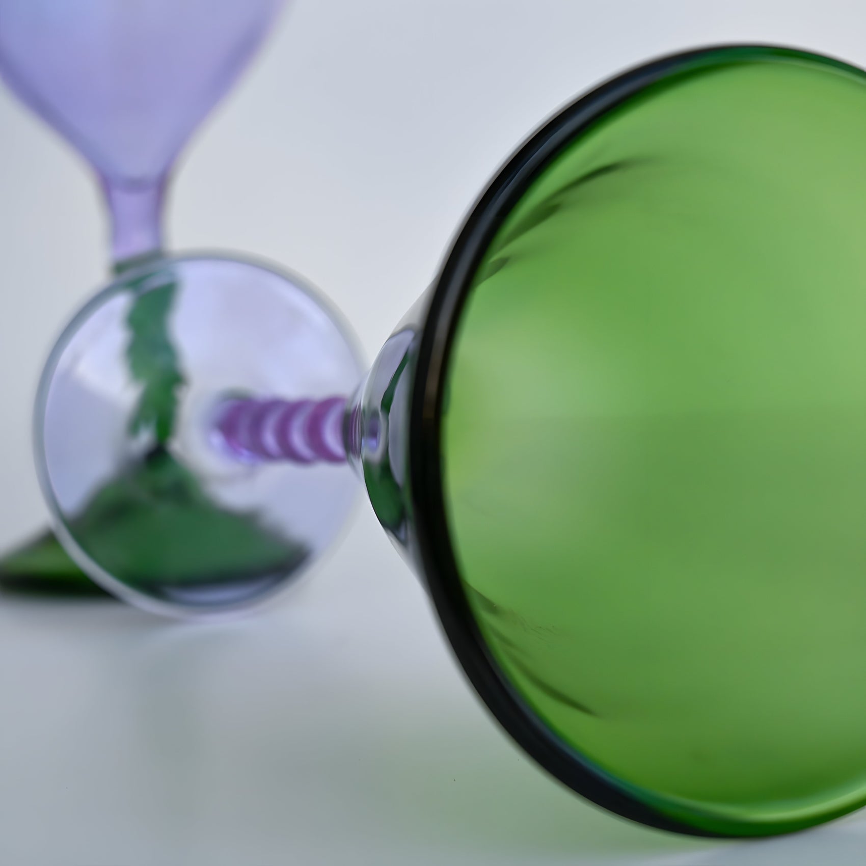 Close-up of a Teta Edit Liquor glass in green and lavender, showcasing intricate details of its handcrafted barware design.